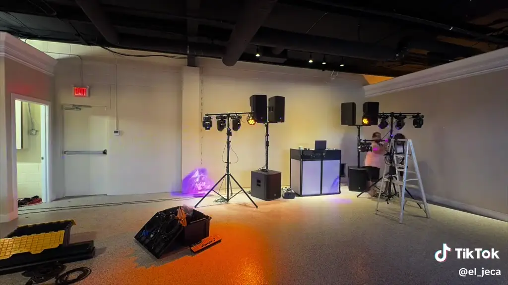 Montaje de bocinas, luces y booth de DJ en un salón de eventos
